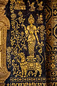 Wat Xieng Thong temple in Luang Prabang, Laos. The facade of the sim decorated with gold stencilling on a black lacquer background. 